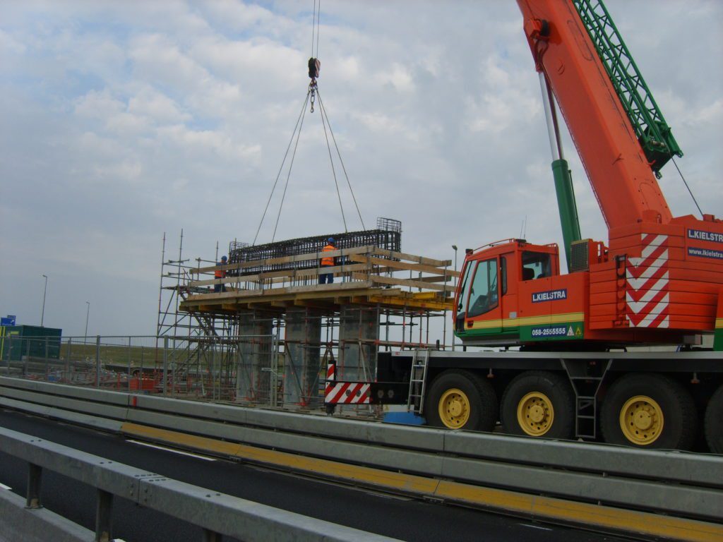 Mobiele kraan bij een viaduct in aanbouw